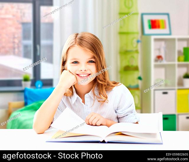 happy smiling student girl reading book at home
