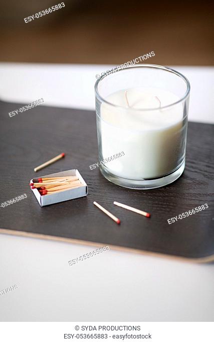 fragrance candle and matches on tray on table