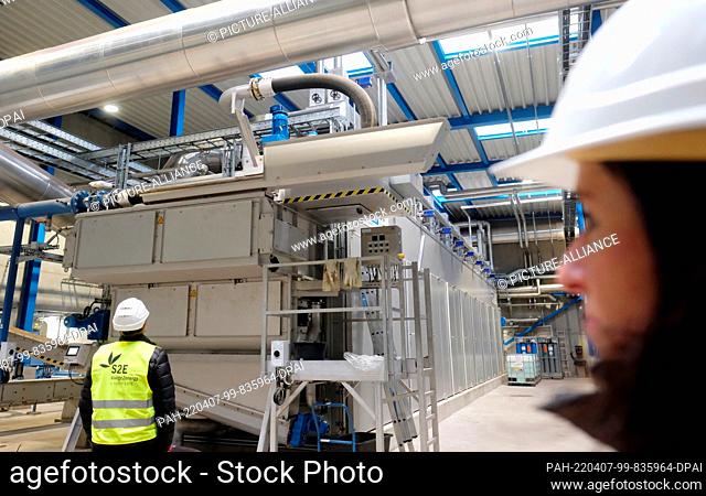 07 April 2022, Hall, Sachsen-Anhalt: Employees of a sewage sludge incineration plant stand in front of a belt drying plant