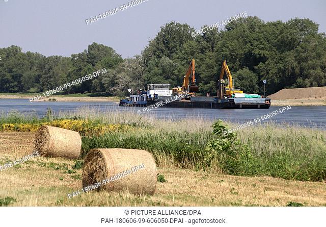 29 May 2018, Schoenebeck, Germany: Specialists work with excavators on a ship on the Elbe. They eliminate shoals in the stream and fortify the shore