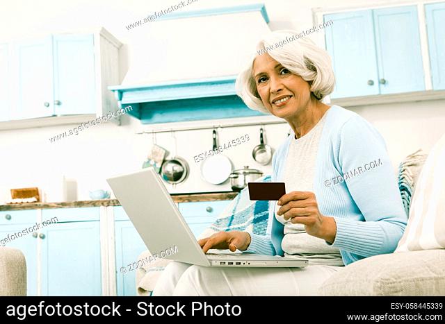 Elderly Woman Buying Goods On Internet Happy Woman Smiling For Camera Pretty Lady Showing Credit Card To Photographer, Toned Image