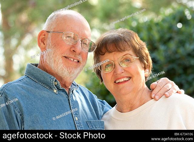 Happy affectionate smiling senior couple outdoor portrait