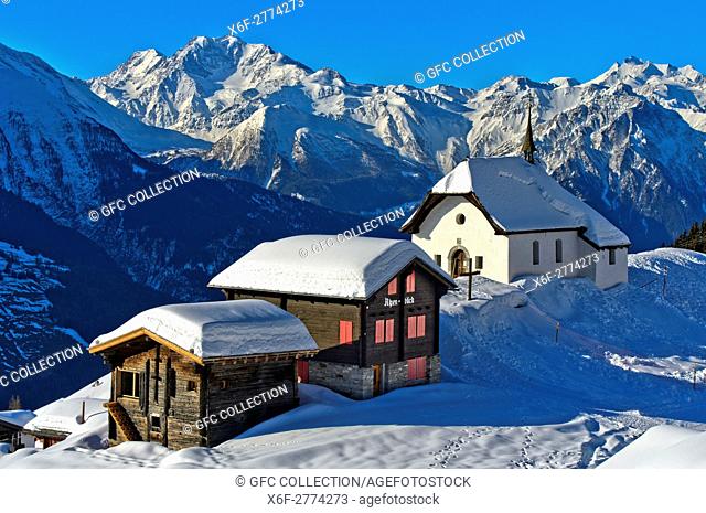 Snow-covered chapel Kapelle Maria zum Schnee against the peaks of the Pennine Alps, Bettmeralp, Valais, Switzerland