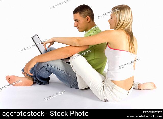 young couple sitting on the floor with laptop