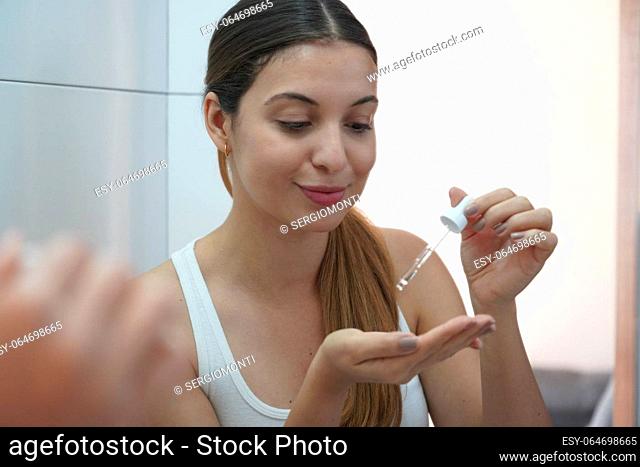 Skin Care Routine. Beautiful young woman holding a pipette in her hand with serum moisturizing anti aging antioxidant
