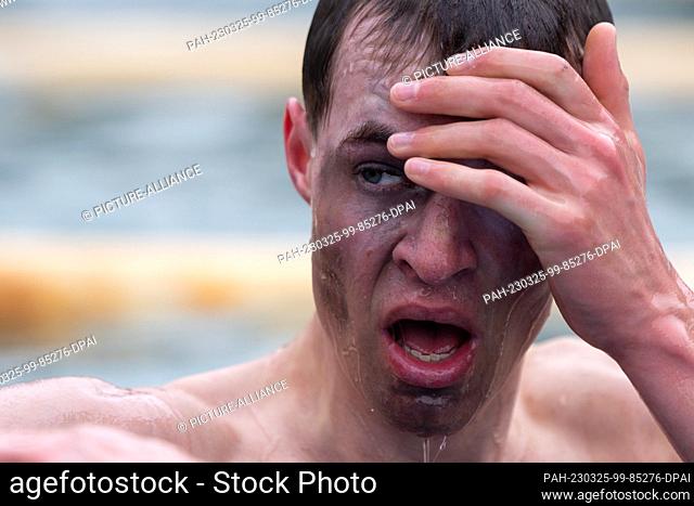 25 March 2023, Thuringia, Steinach: A participant of the obstacle race ""Braveheartbattle"" overcomes an obstacle course in the cold outdoor pool water