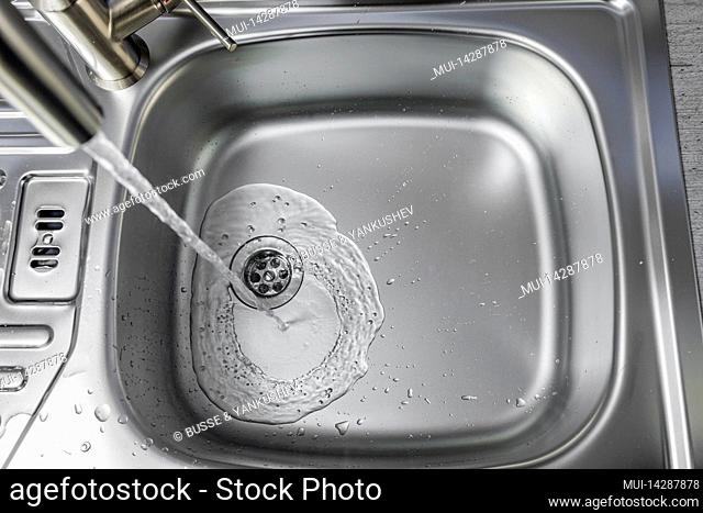 Water flows from a faucet into a sink