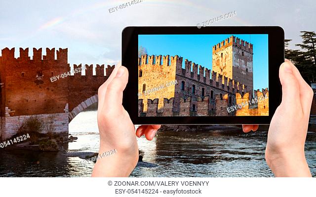 travel concept - tourist photographs Castelvecchio (Scaliger) Castel in Verona city in Italy in spring evening on tablet