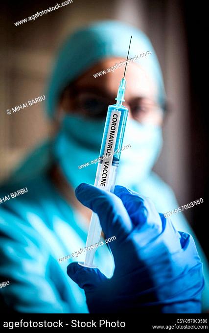 Conceptual image of a nurse holding a syringe with the coronavirus COVID-19 vaccine