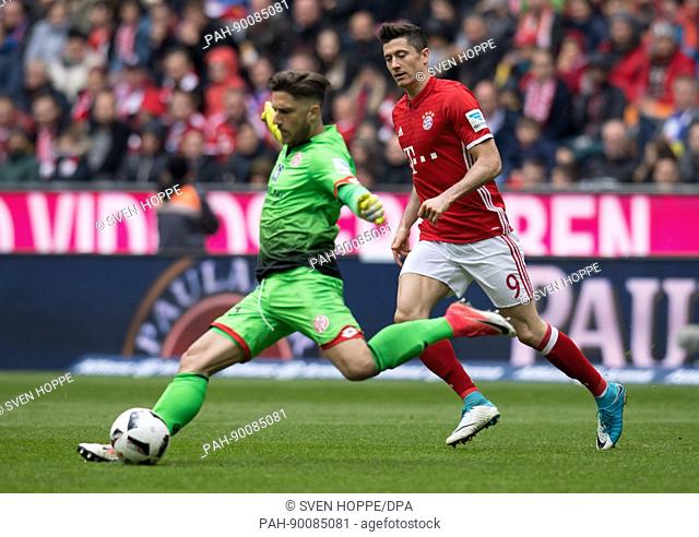 Munich's Robert Lewandowski (R) and Mainz' goalkeeper Jannik Huth vie for the ball during the German Bundesliga soccer match between Bayern Munich and FSV Mainz...