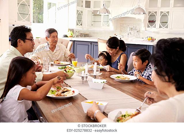 Extended Family Group Eating Meal At Home Together