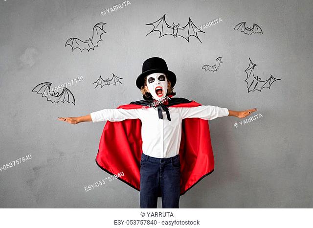 Funny child dressed Halloween costume. Kid painted terrible vampire. Autumn holiday concept