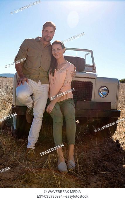 Portrait of couple by parked off road vehicle