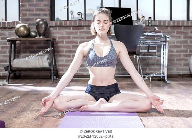 Young woman doing yoga exercise in studio