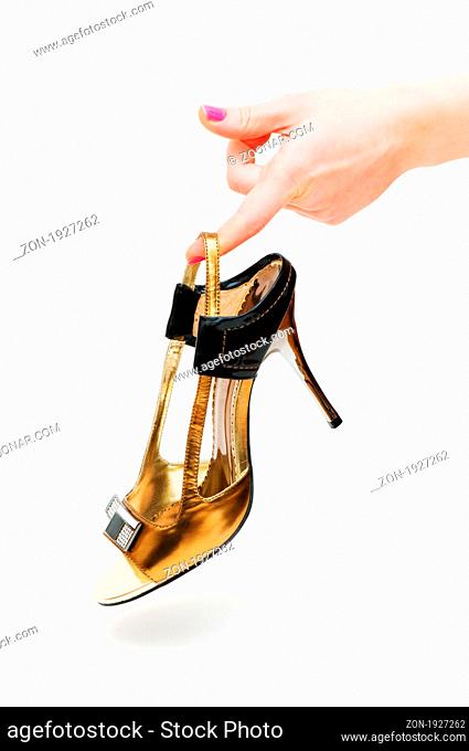 Hand holding woman shoe isolated on white
