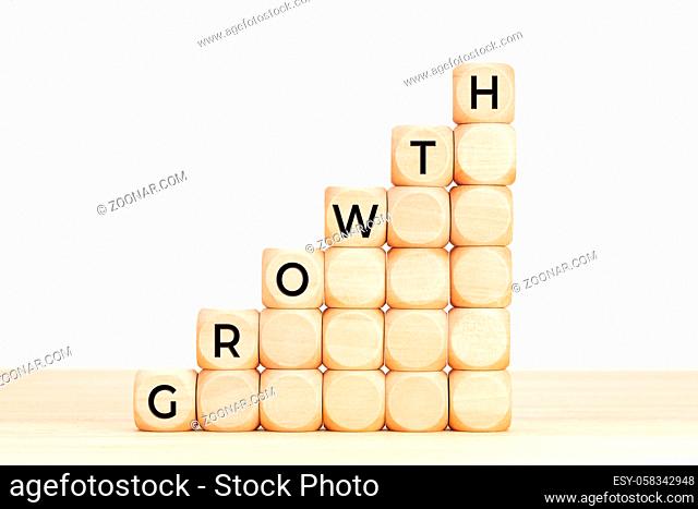 Growth concept. Text in wooden dices on table. White background. Copy space