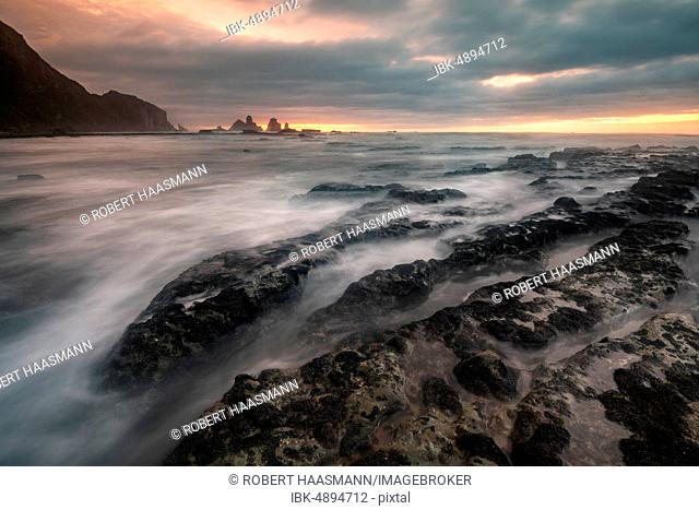 Rocky coast washed by the sea, dramatic light atmosphere, rocks in the sea, Greymouth, West Coast region, South Island, New Zealand