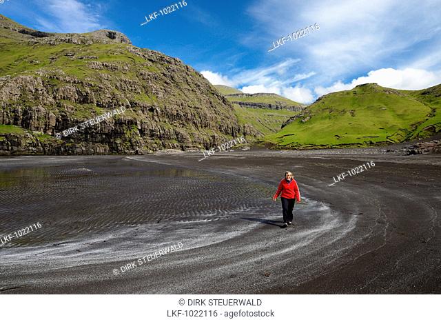 Woman on the lava beach at Saksun, Streymoy Island, Faroe Islands