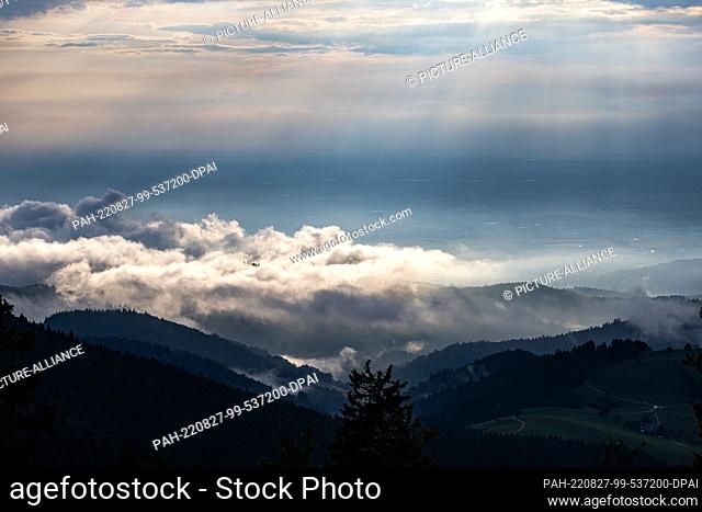 27 August 2022, Baden-Wuerttemberg, Freiburg: Clouds move over the foothills of the Black Forest, while in the background the Rhine plain can be seen