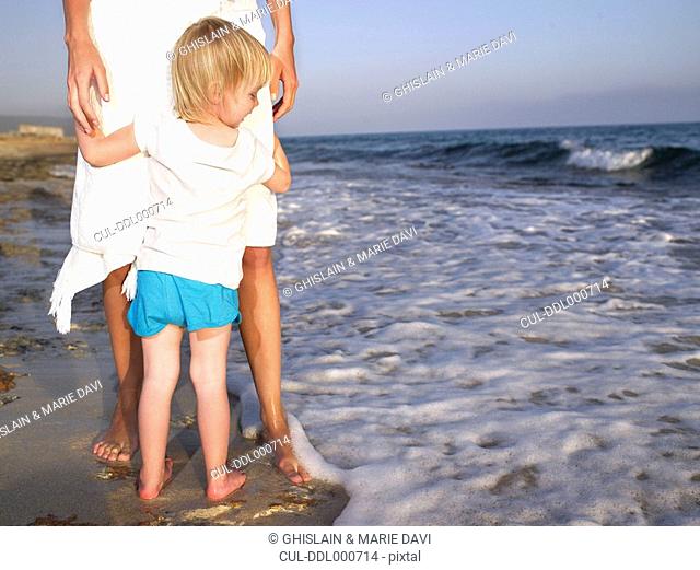 Woman standing with a young girl at the beach