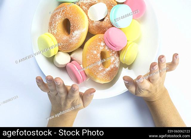 Woman hands making a hand sign of no and refuse for a white plate with fastfood and sugar, top view, healtcare and weightloss concept