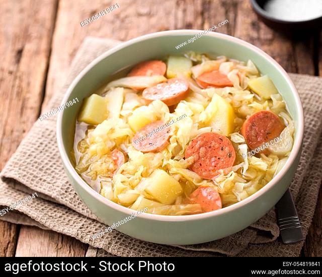 Fresh homemade cabbage, potato and sausage stew in bowl (Selective Focus, Focus one third into the dish)