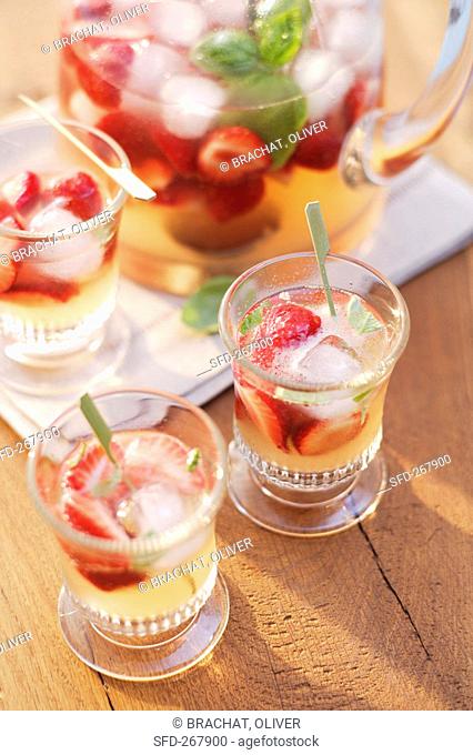 Strawberry punch with basil in glasses and glass jug