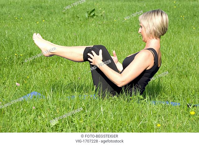 woman does pilates in meadow - 06/10/2009