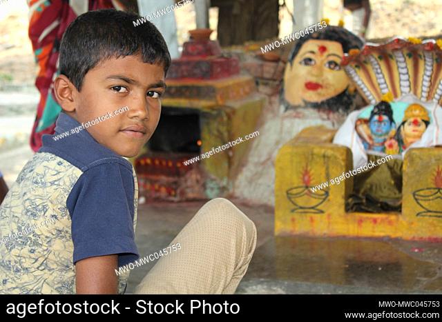 A boy seated at a place of worship. India