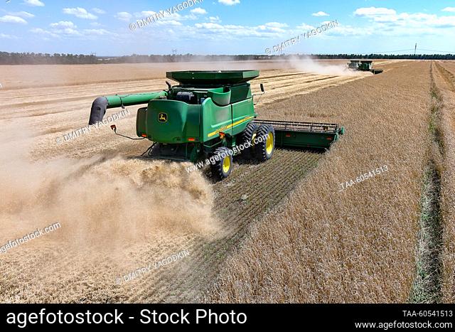 RUSSIA, DONETSK PEOPLE'S REPUBLIC - JULY 19, 2023: Combines harvest wheat as Volodarsky District enters an early crops and legumes harvest campaign