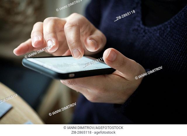 Close-up of woman using touch screen mobile phone