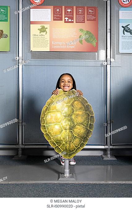 Girl standing behind kemps ridley sea turtle shell