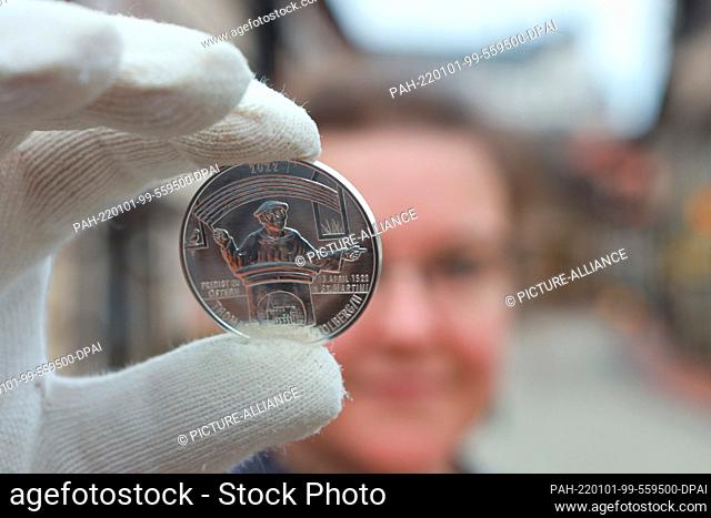 01 January 2022, Saxony-Anhalt, Stolberg: Museum employee Gesine Kulow presents a silver medal depicting Thomas Müntzer. This year's annual medal with a motif...