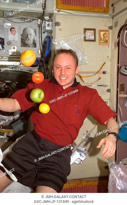 Astronaut Edward M. (Mike) Fincke, Expedition 9 NASA ISS science officer and flight engineer, is pictured near fresh fruit floating freely in the Zvezda Service...