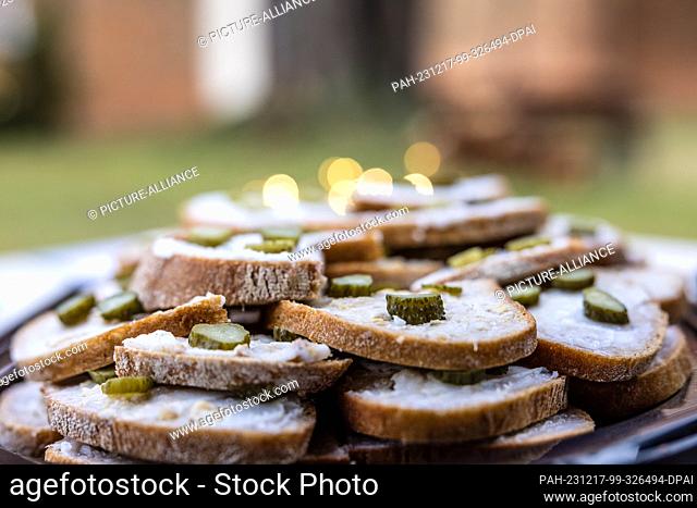 16 December 2023, Brandenburg, Leuthen: Schmalzstullen lie on a plate at a stall at a small Advent market. Advent and Christmas markets are also held in many...