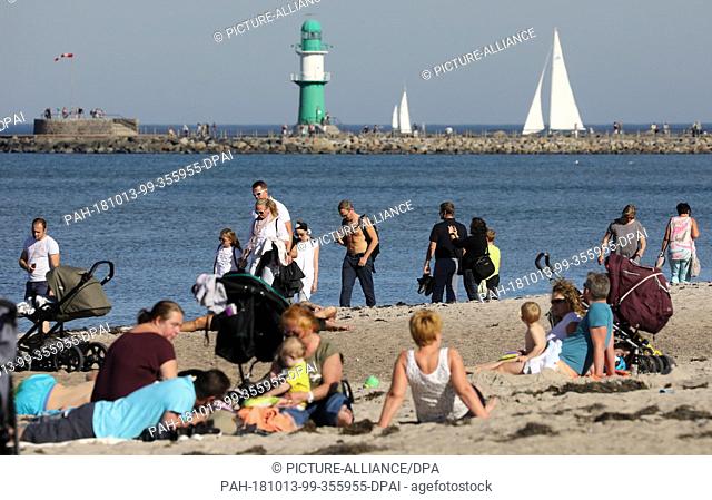 13 October 2018, Mecklenburg-Western Pomerania, Warnemuende: Beach-goers enjoying the summer weather at the Baltic Sea. Photo: Bernd Wüstneck/dpa