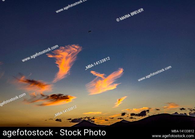 airplane over the clouds, cloud formations at sunset, behind the volcanoes of timanfaya, lanzarote, canaries, canary islands, spain, europe