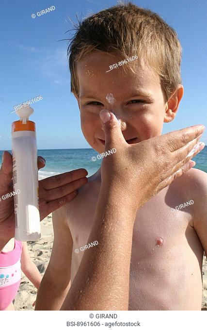 SHIELDING FROM SUNBURN 5-year-old boy with suntan screen on