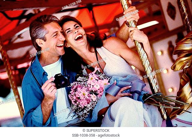 Mid adult couple on a carousel