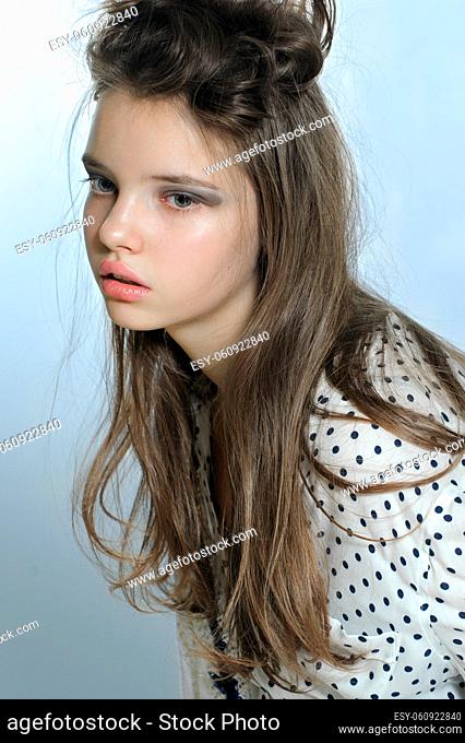 Portrait of teen girl in a stylish shirt and casual hairdo. Fashion photography in a soft tone