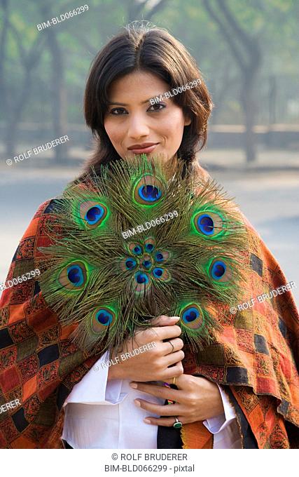 Indian woman holding peacock feather fan