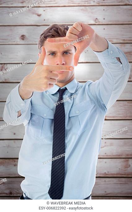 Composite image of businessman making frame with hands