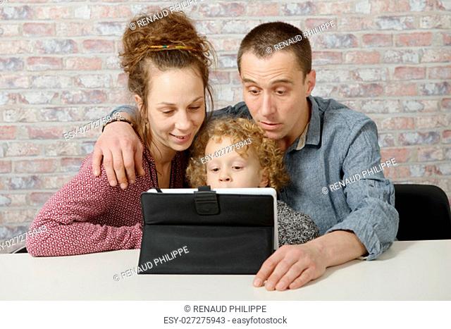 happy young family playing with a tablet computer
