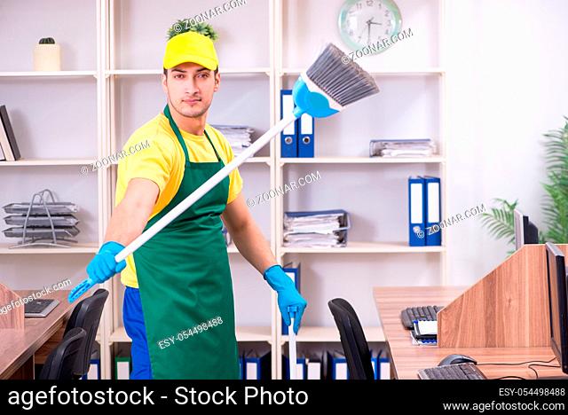 The young male contractor cleaning the office