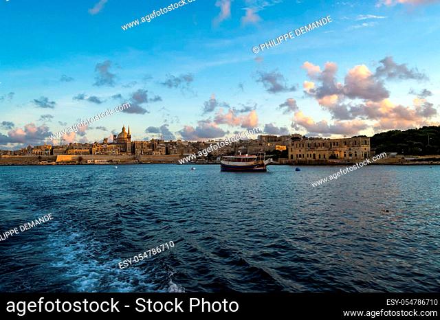 Panoramic view of Valletta Skyline at beautiful sunset from Sliema with churches of Our Lady of Mount Carmel and St. Paul's Anglican Pro-Cathedral, Valletta