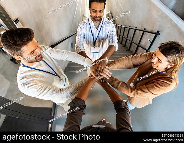 group of business people stacking hands at office
