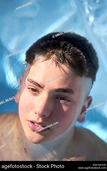 Portrait of ayoung caucasian boy inside swimming pool in summer. Lifestyle concept