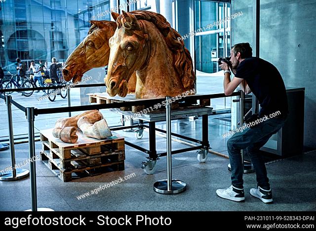 11 October 2023, Berlin: A man photographs plaster casts of horses of the Quadriga in the exhibition ""The Secrets of the Quadriga