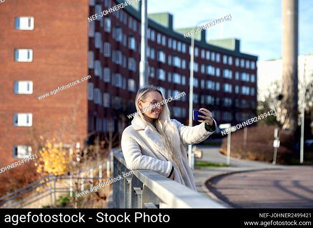 Young woman taking selfie in street