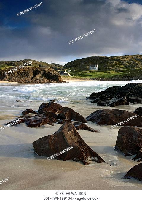 Scotland, Highland, Lochinver. Waves roll in onto the shore during high tide at the remote and picturesque Clachtoll Bay